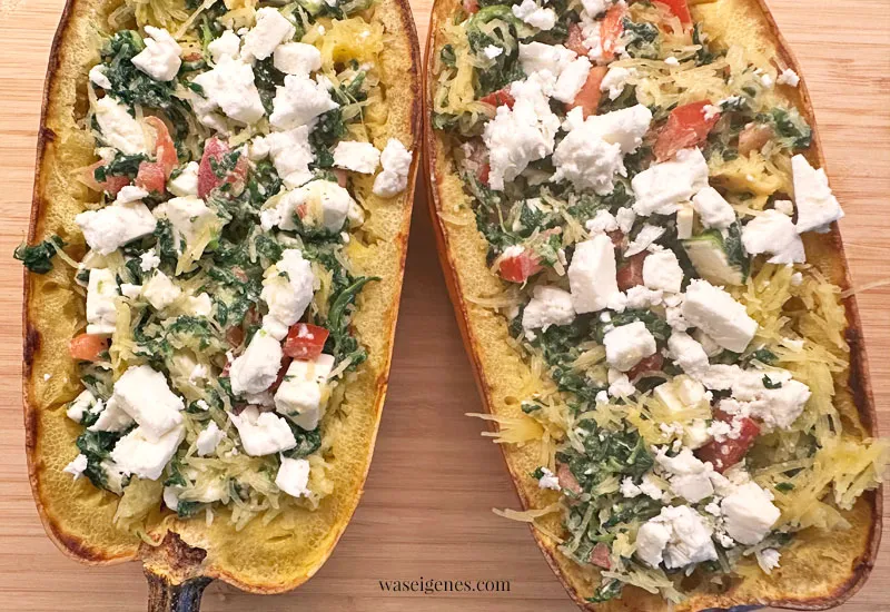 Eine Spaghettikürbis-Hälfte, gefüllt mit der Spinat-Feta-Kürbismischung
