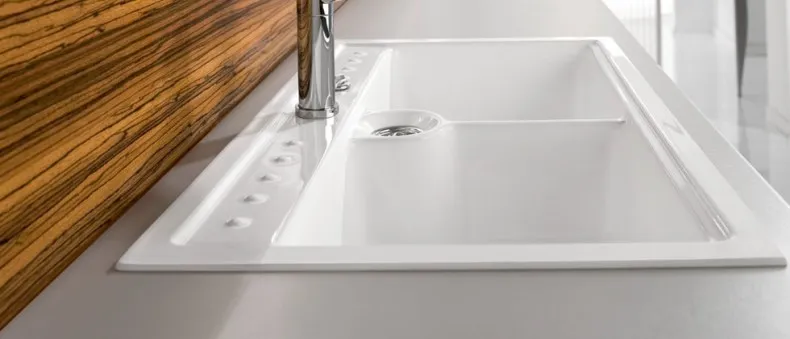 Eine weiße Keramikspüle mit einer sanft geschwungenen Formgebung, minimalistisch und elegant