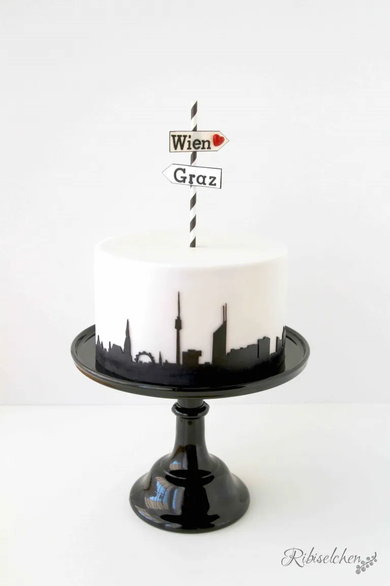 Eine wunderschöne, aufwendig verzierte Schokoladentorte mit der Aufschrift „Wien“ und „Viel Glück!“ für einen Abschied