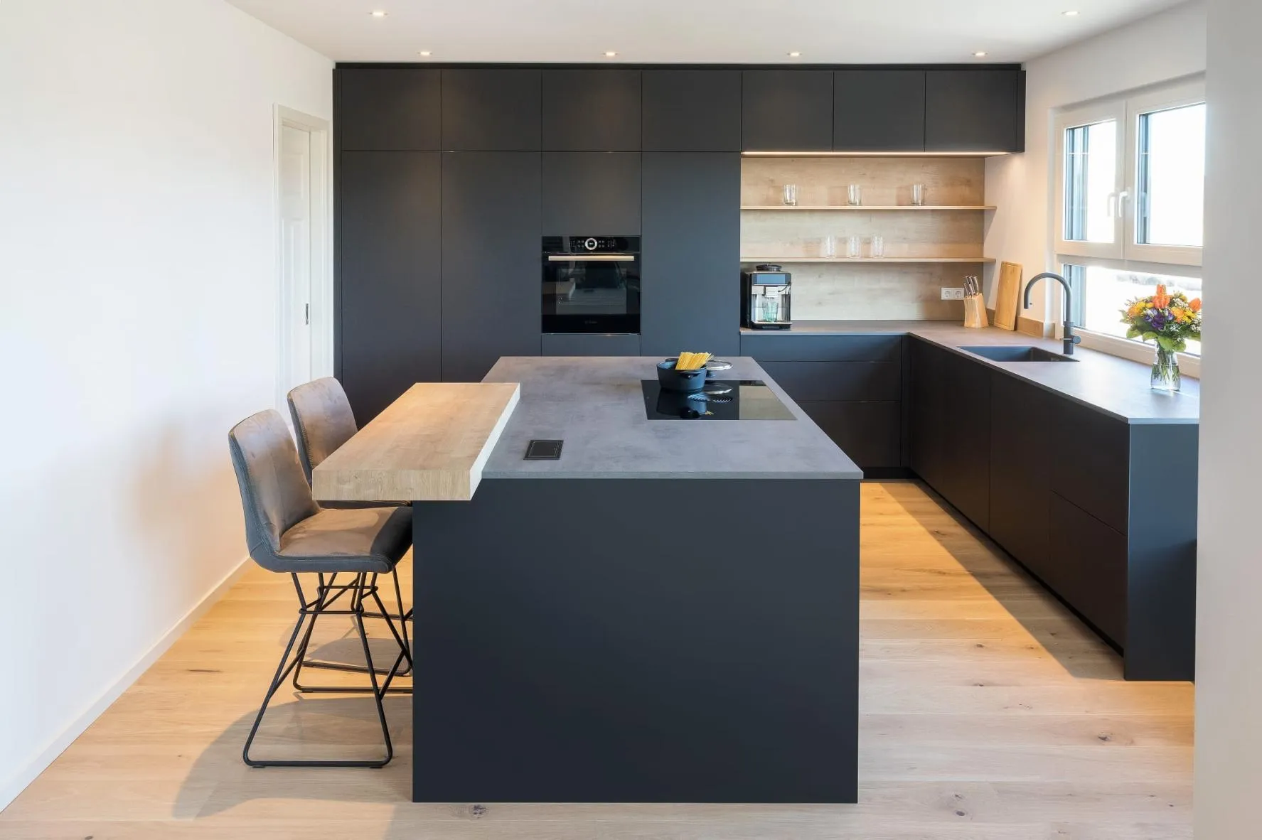 Elegante schwarze Kücheninsel mit Theke und passenden Hockern