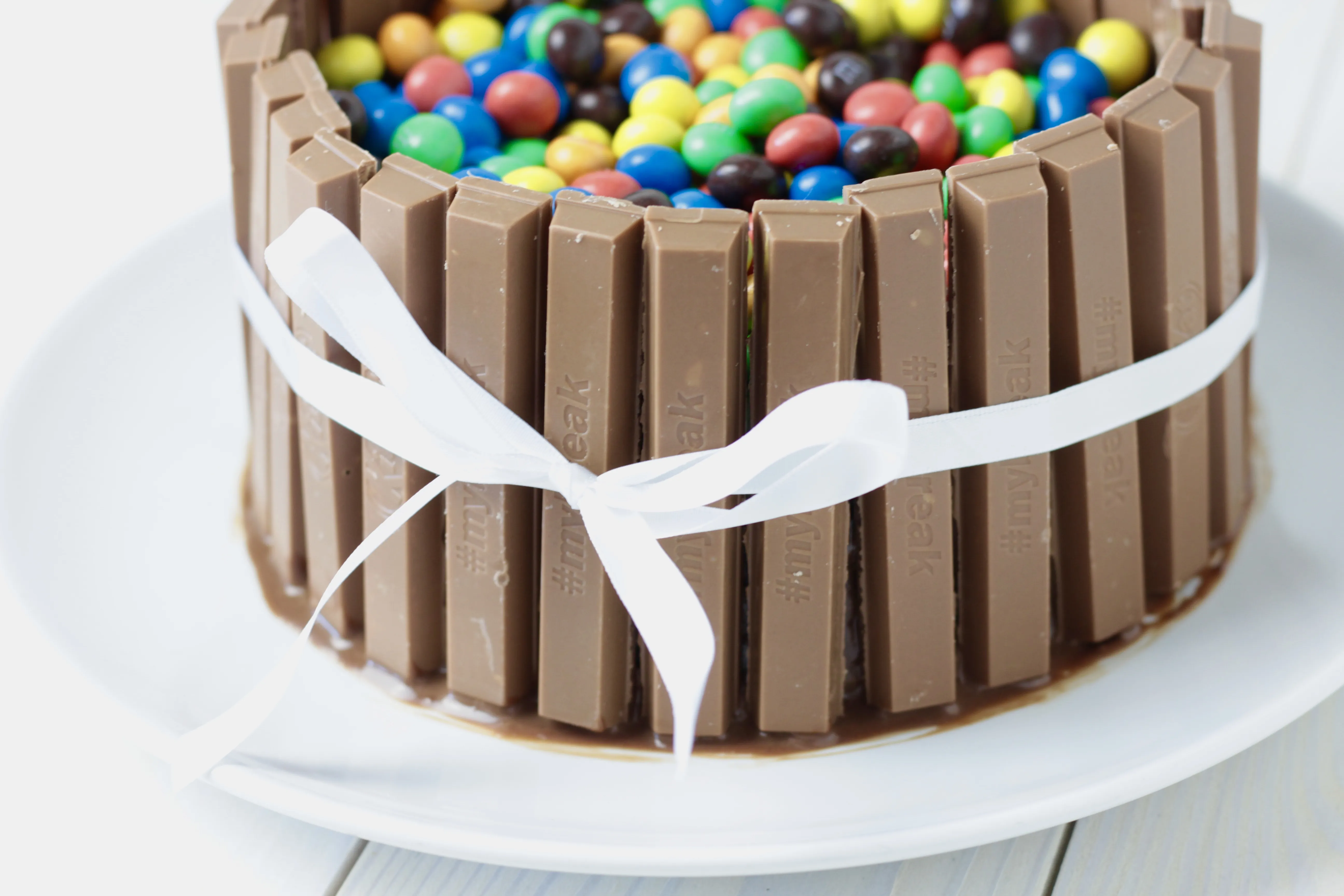 Farbenfroher Candy Cake dekoriert mit KitKats und M&Ms