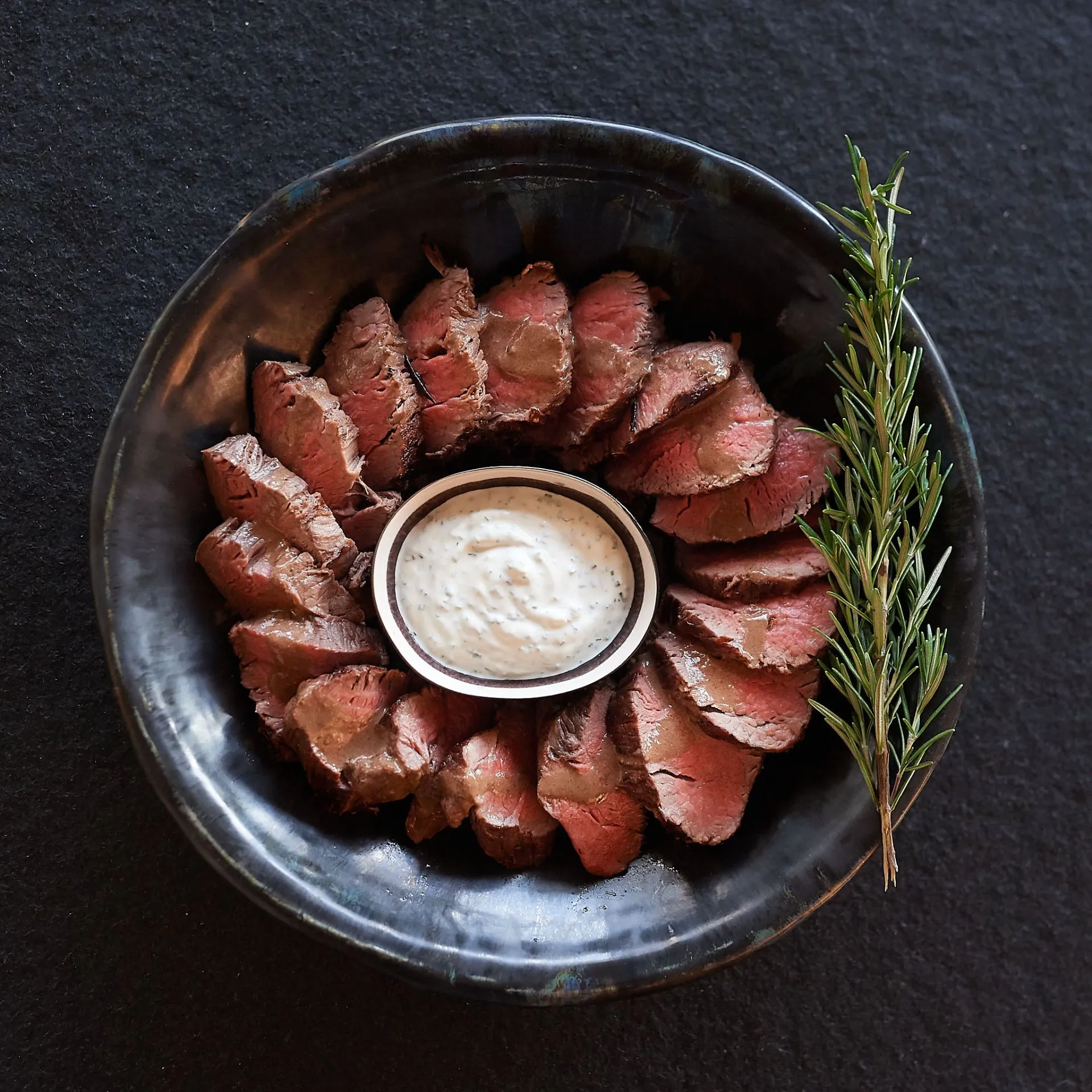 Feine Streifen vom Rinderfilet in Schuessel serviert mit selbstgemachter Sauce