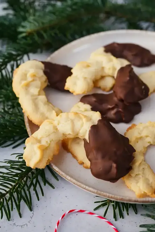 Fertiges Spritzgebäck mit Schokoladenenden, weihnachtlich arrangiert