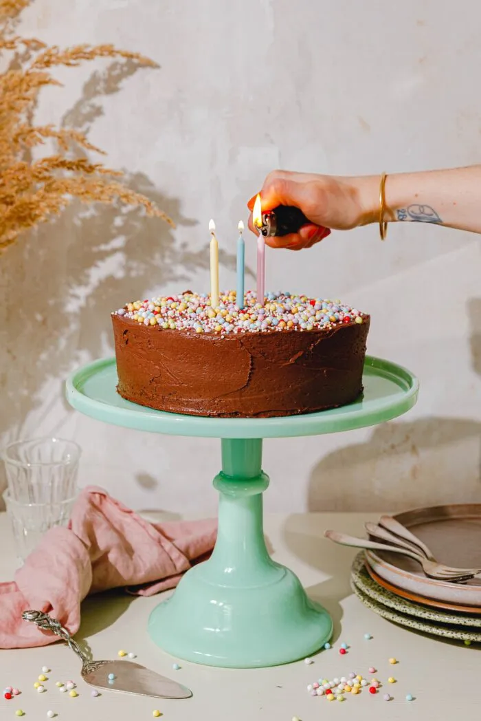 Festlich dekorierter veganer Geburtstagskuchen mit Schoko-Frosting und bunten Streuseln