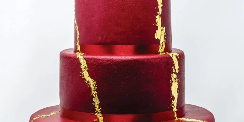 Festtagstorte in kräftigem Rot mit goldener Verzierung