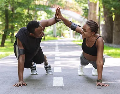 Fitnesstrainer mit einem Klienten in einem Fitnessstudio, zeigt eine Übung