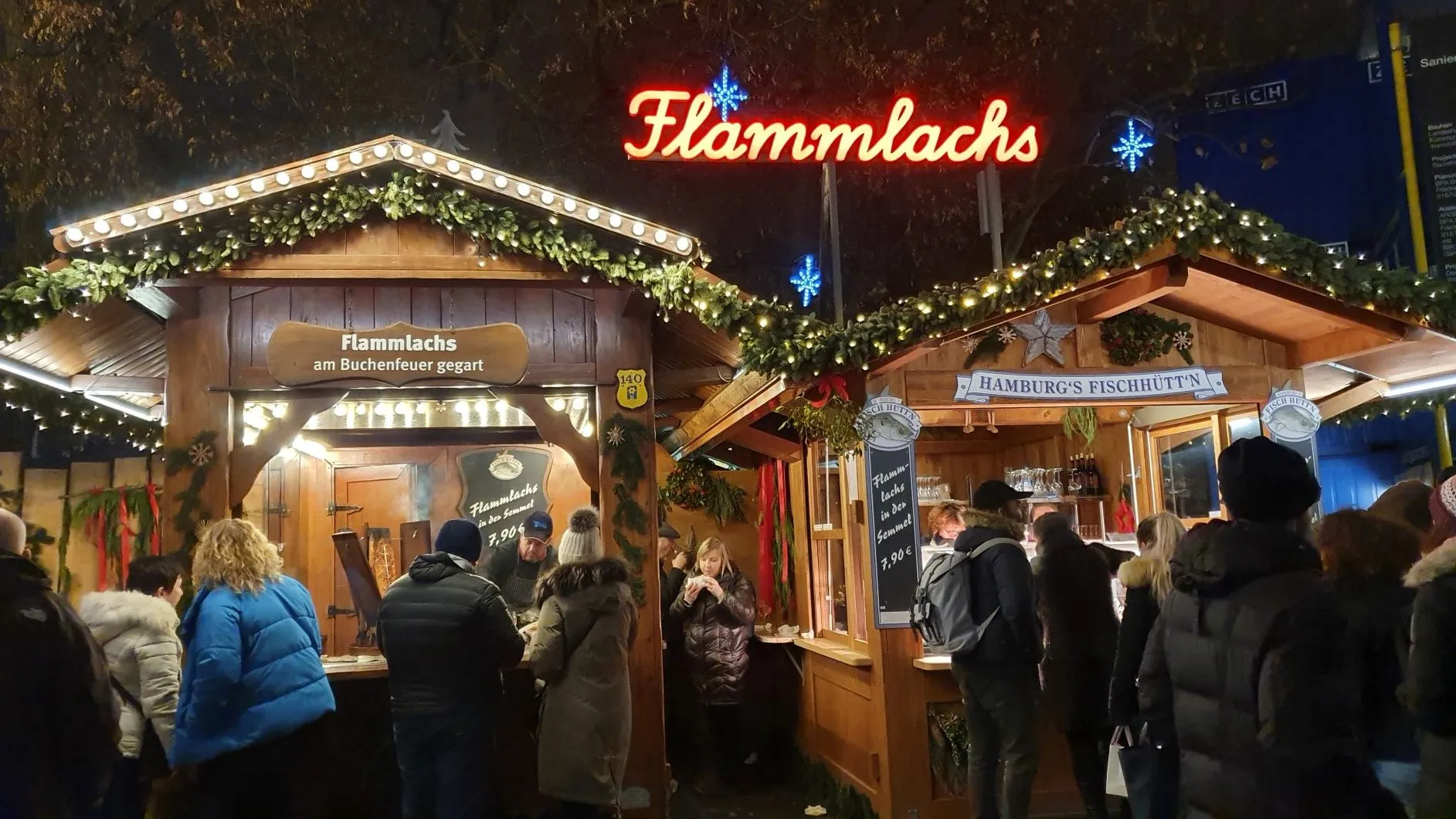 Flammlachsstand auf einem deutschen Weihnachtsmarkt mit Besucherandrang