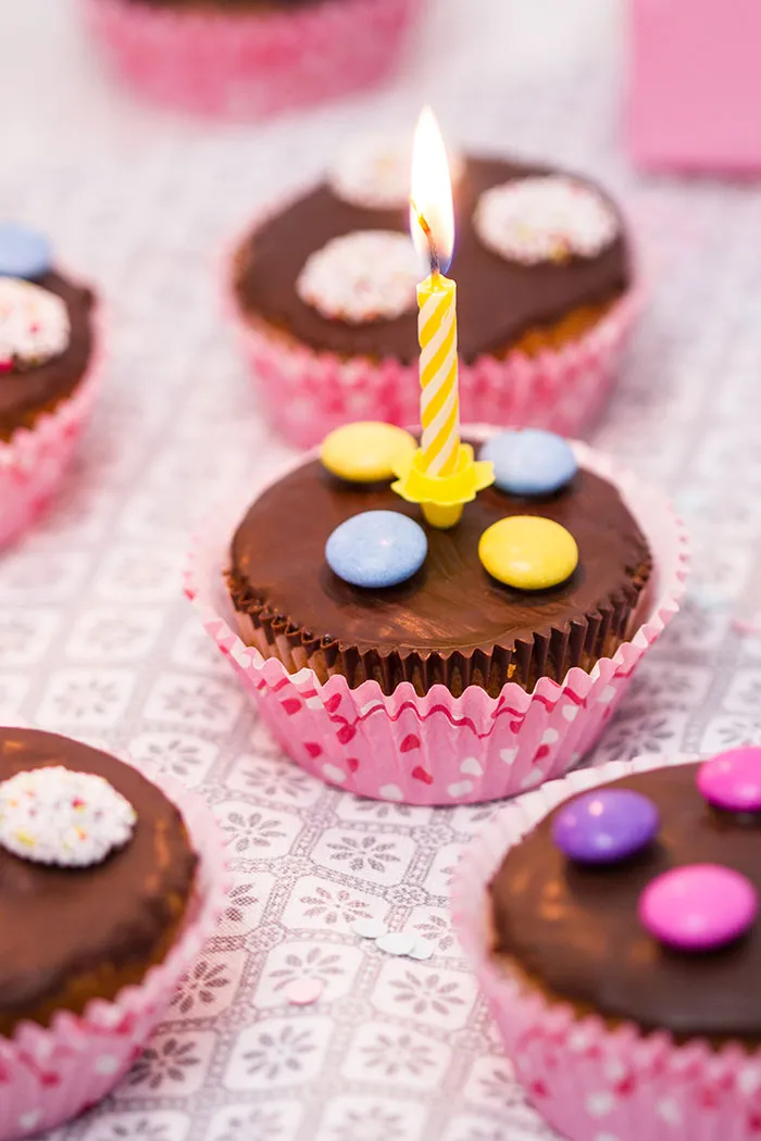 Frisch gebackene Geburtstagsmuffins mit bunter Dekoration