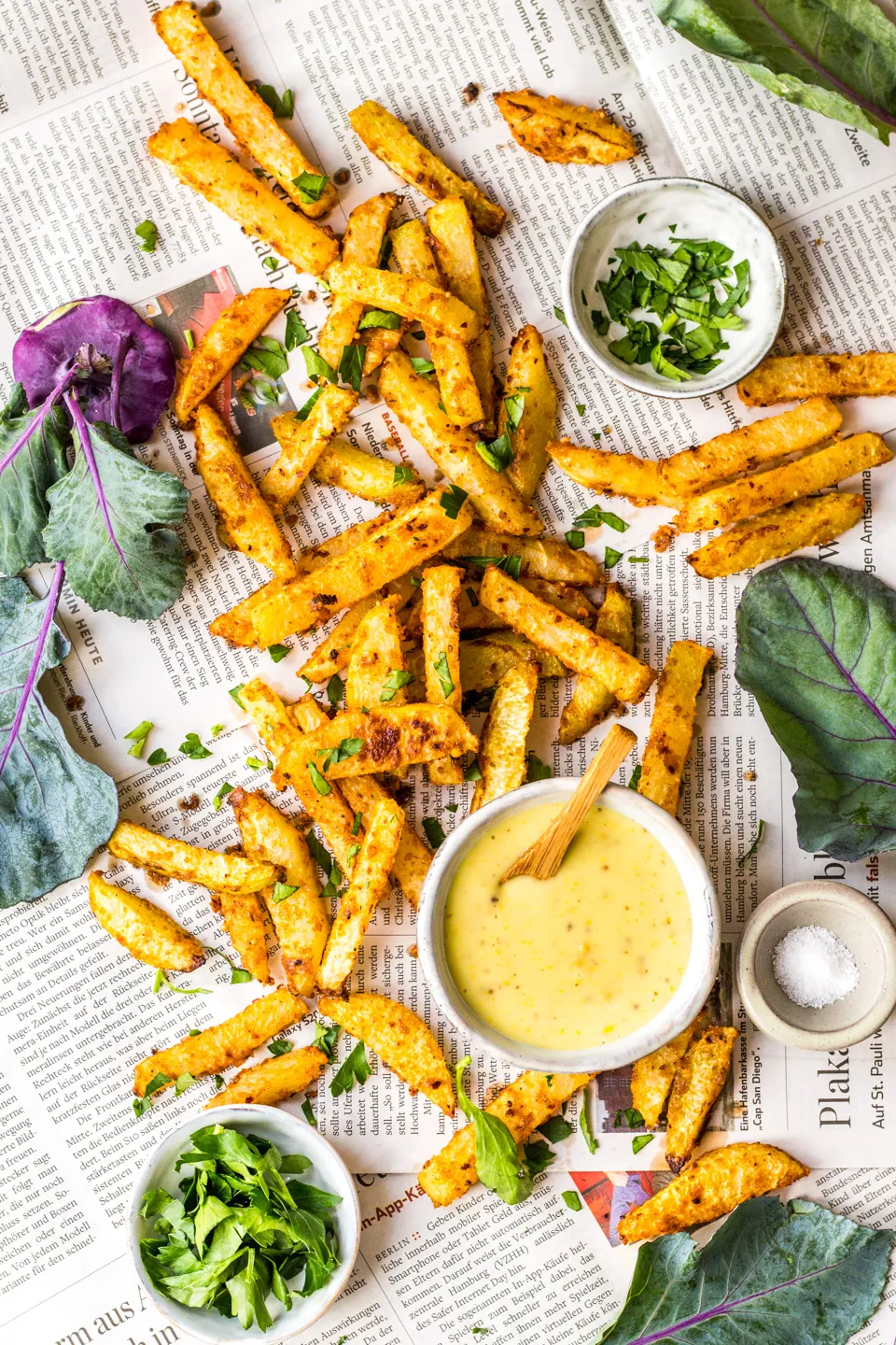 Frisch gebackene Kohlrabi-Pommes auf Zeitungspapier angerichtet