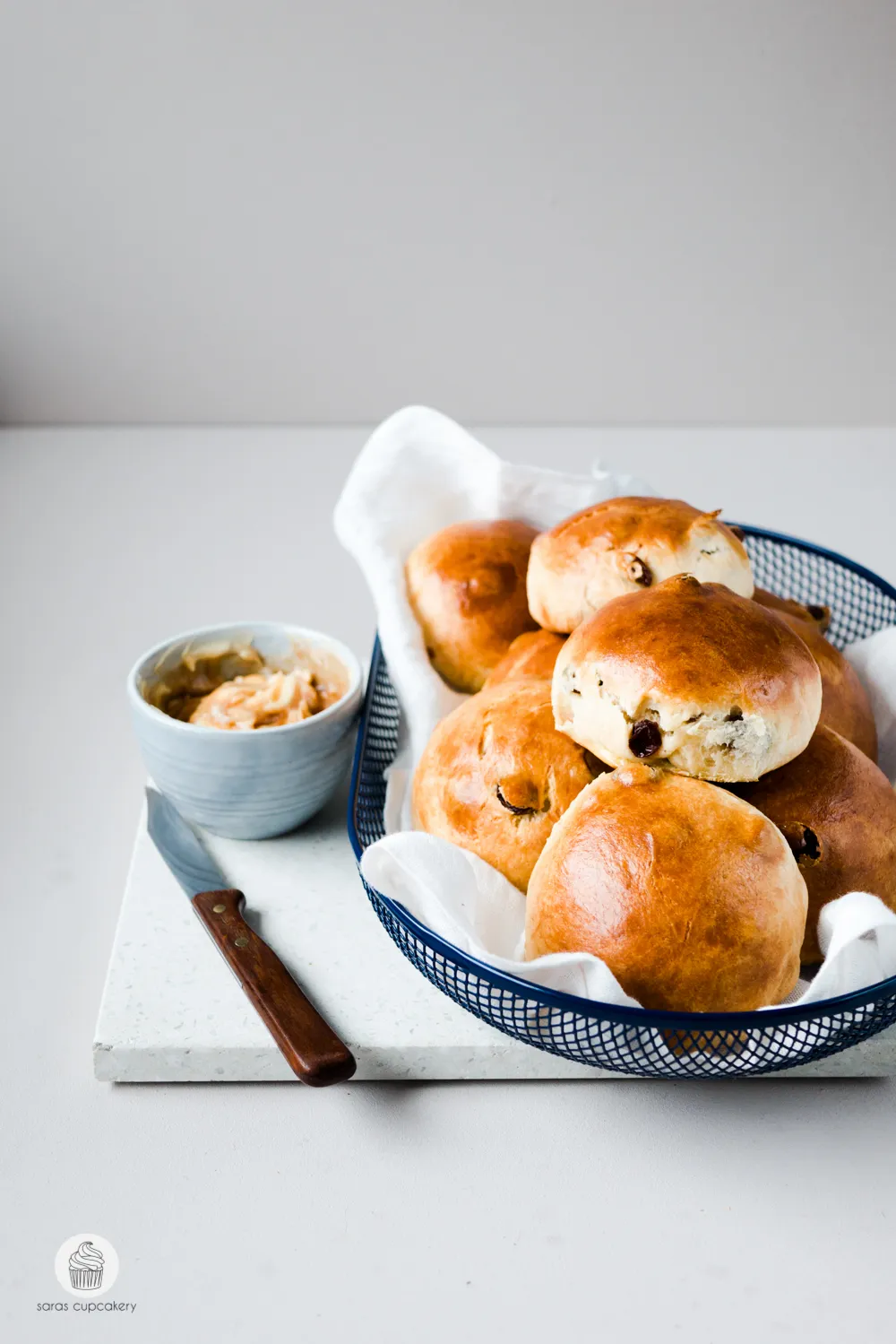 Frisch gebackene Rosinenbrötchen auf einem Holzbrett