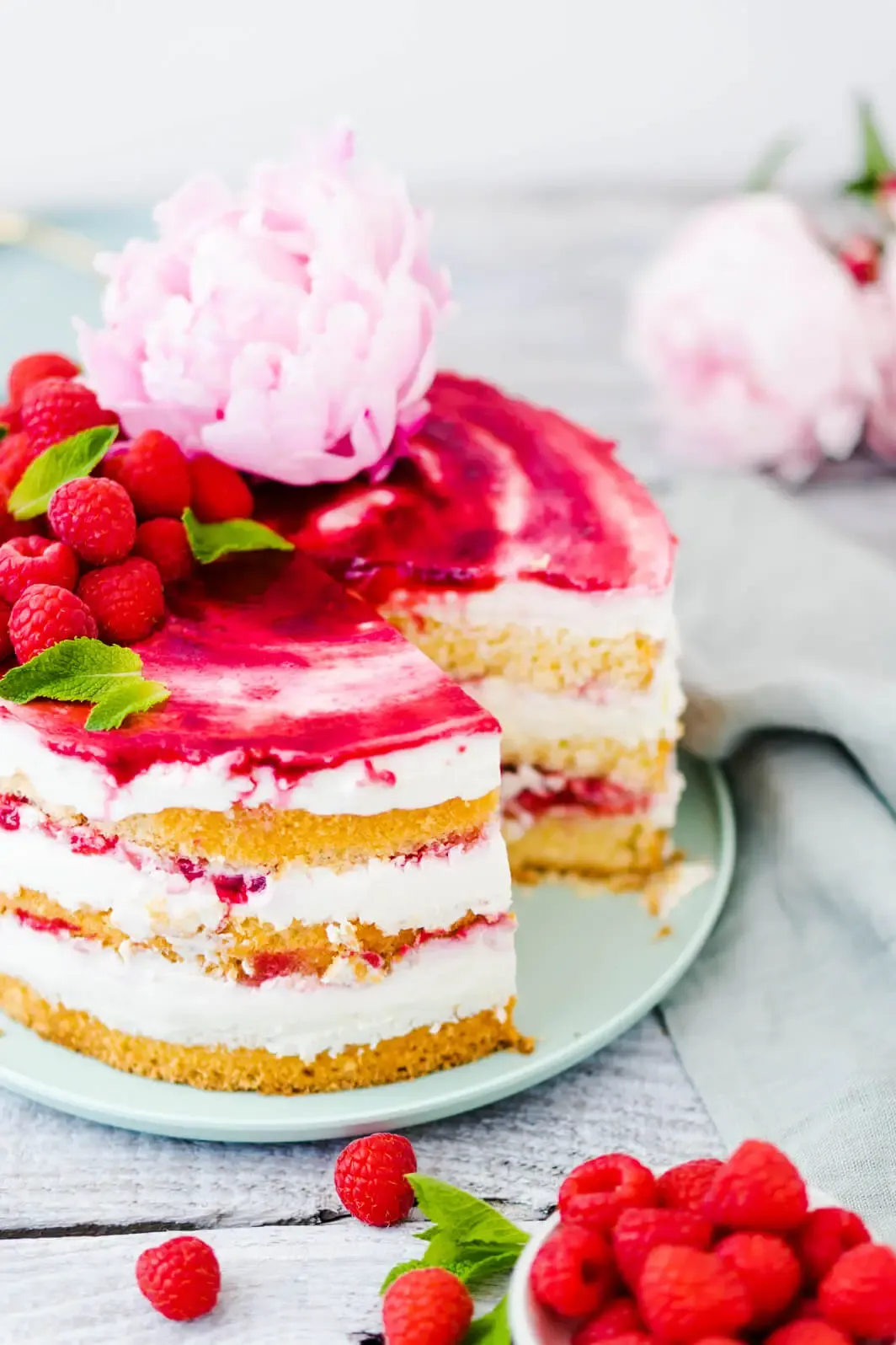 Frische Himbeeren und Minze dienen als appetitliche Dekoration auf der Torte