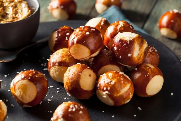 Frische Laugengebäck-Stücke mit Käse und Salz als Partysnack