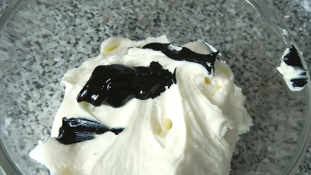 Frischkäse-Frosting wird mit roter Lebensmittelfarbe gefärbt