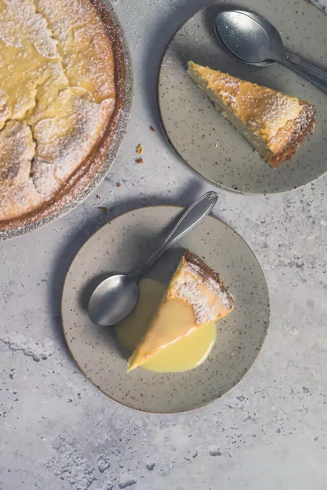 Ganze Ansicht eines Eierlikör Käsekuchens ohne Boden mit Blumen-Puderzucker