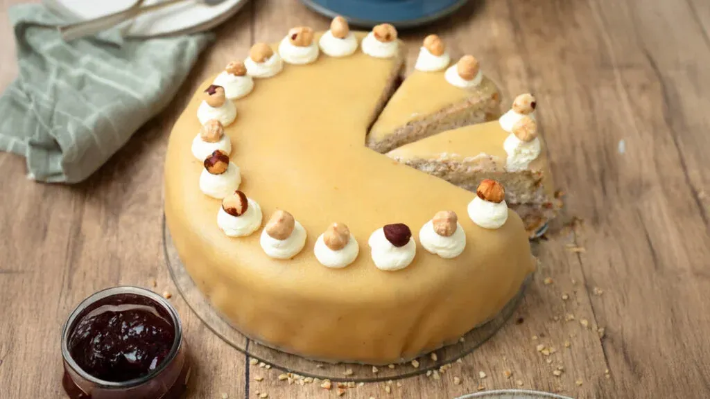 Ganze Marzipan Nuss Torte, perfekt dekoriert mit Sahnetupfen und Nüssen