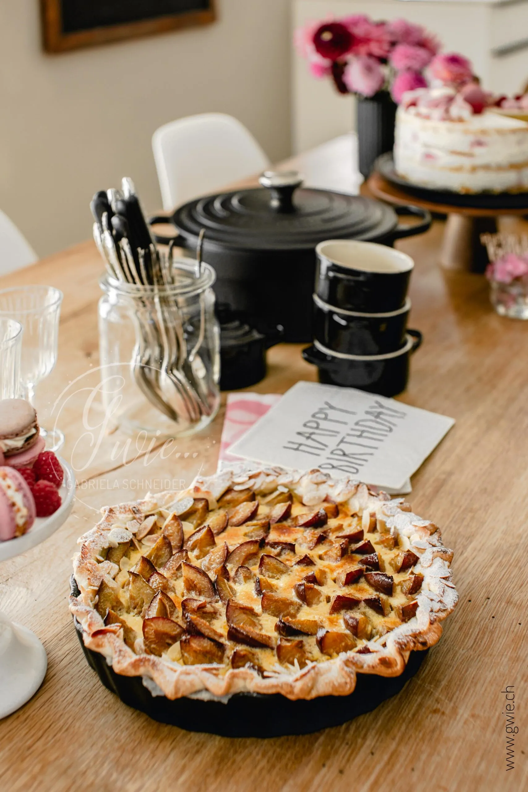 Geburtstagstorte mit Macarons, Meringues und frischen Himbeeren auf weißem Hintergrund