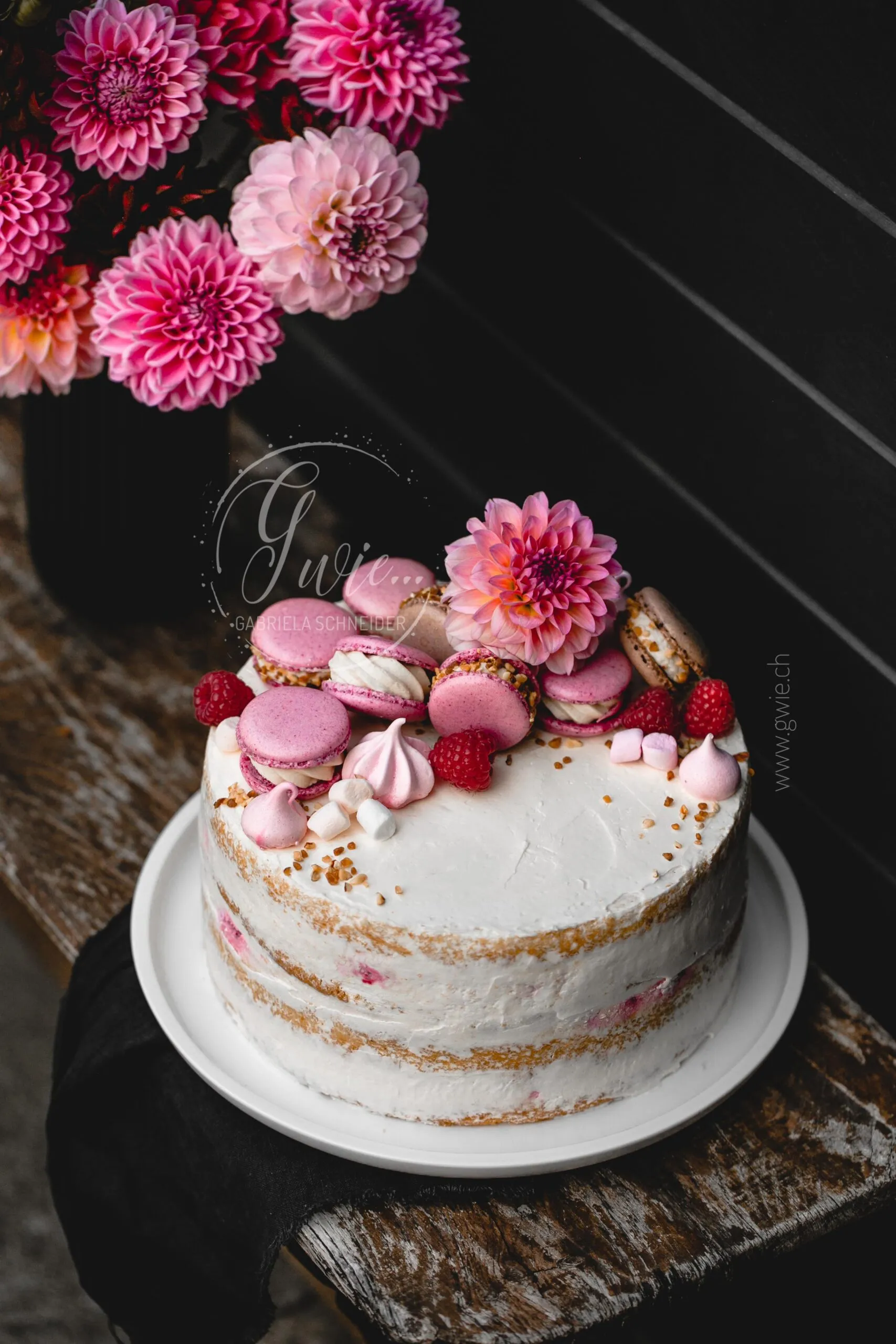 Geburtstagstorte mit sommerlicher Dekoration vor einem Gartentor