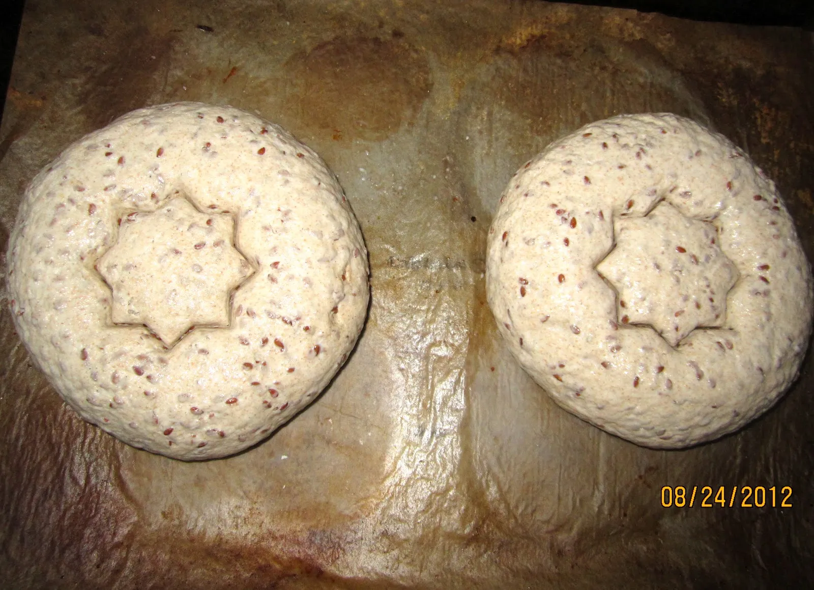 Geformte und mit Ausstechern verzierte Leinsamenbrotkugeln auf dem Backblech