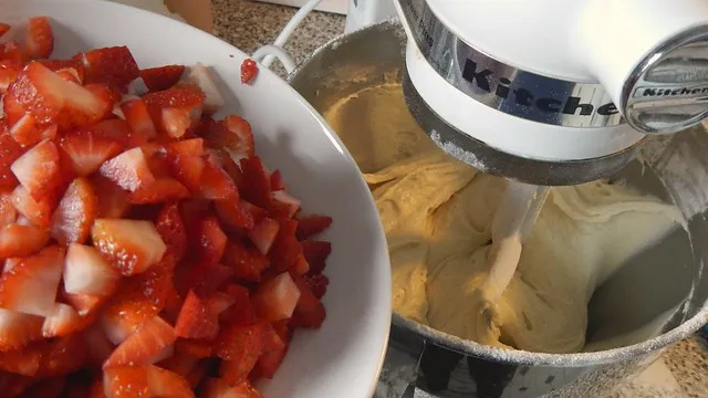 Gehackte Erdbeeren werden in den Teig gegeben