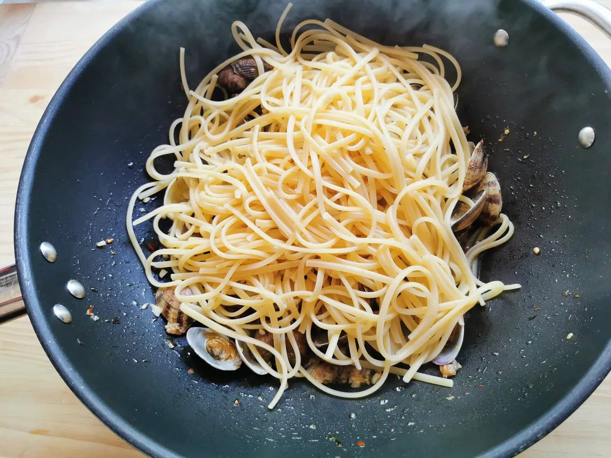 Gekochte Linguine in Pfanne mit Muscheln.
