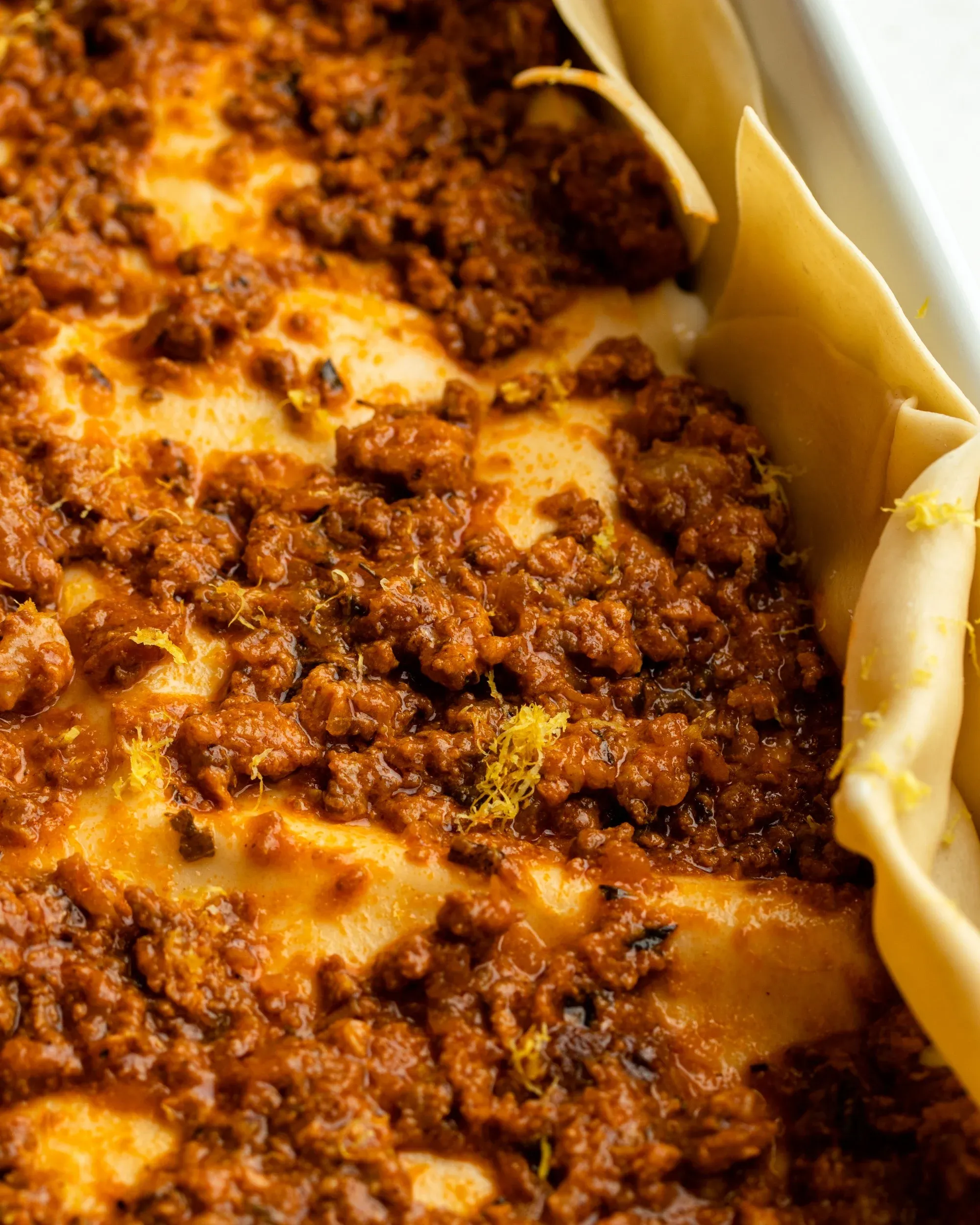 Geriebene Zitronenschale auf einer Fleischschicht