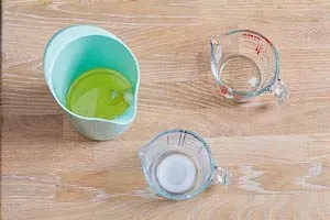 Geschälten Knoblauchzehen, Milch und Öl in ein Mixgefäß geben.