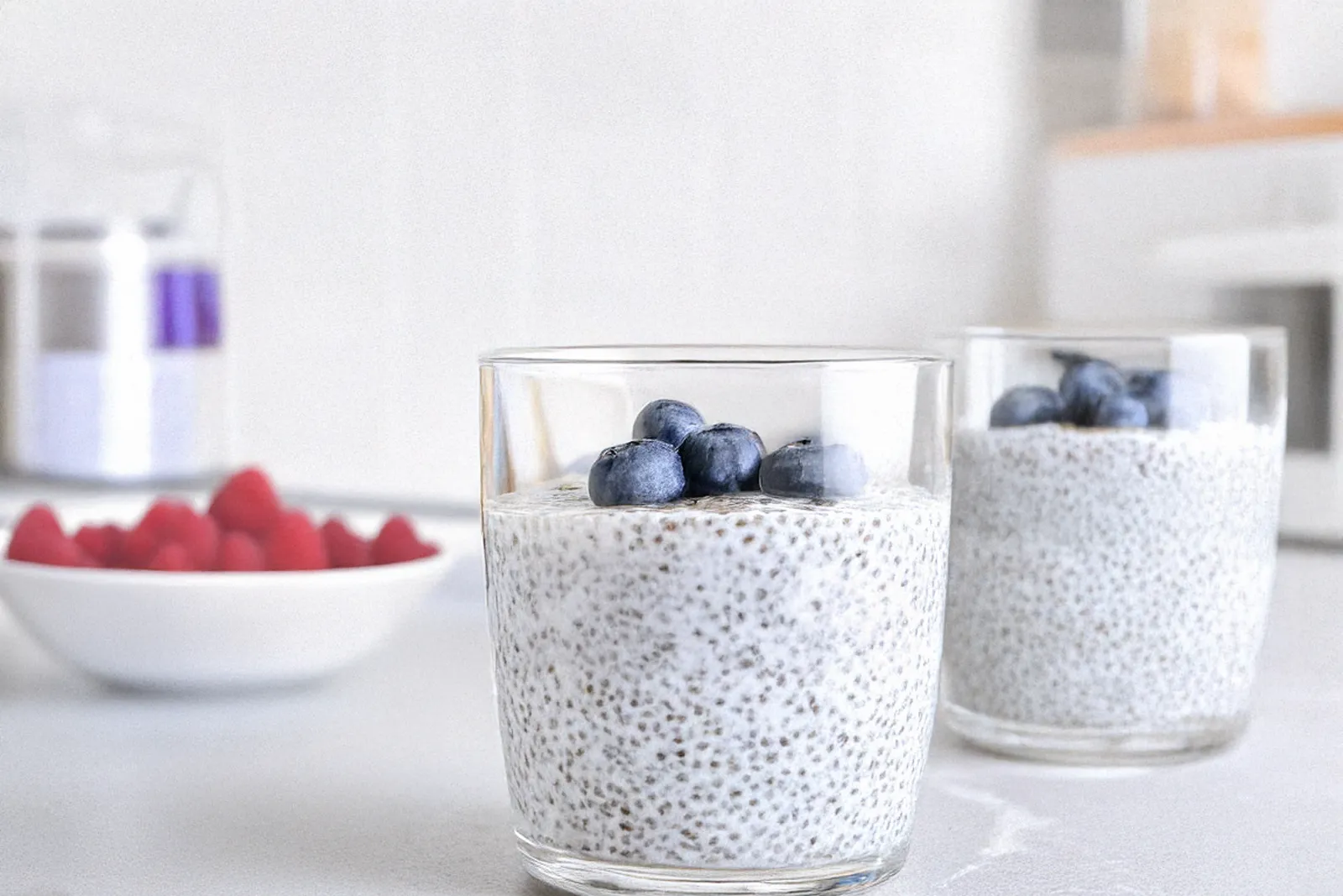 Glas mit cremigem Chia Pudding, getoppt mit frischen Blaubeeren