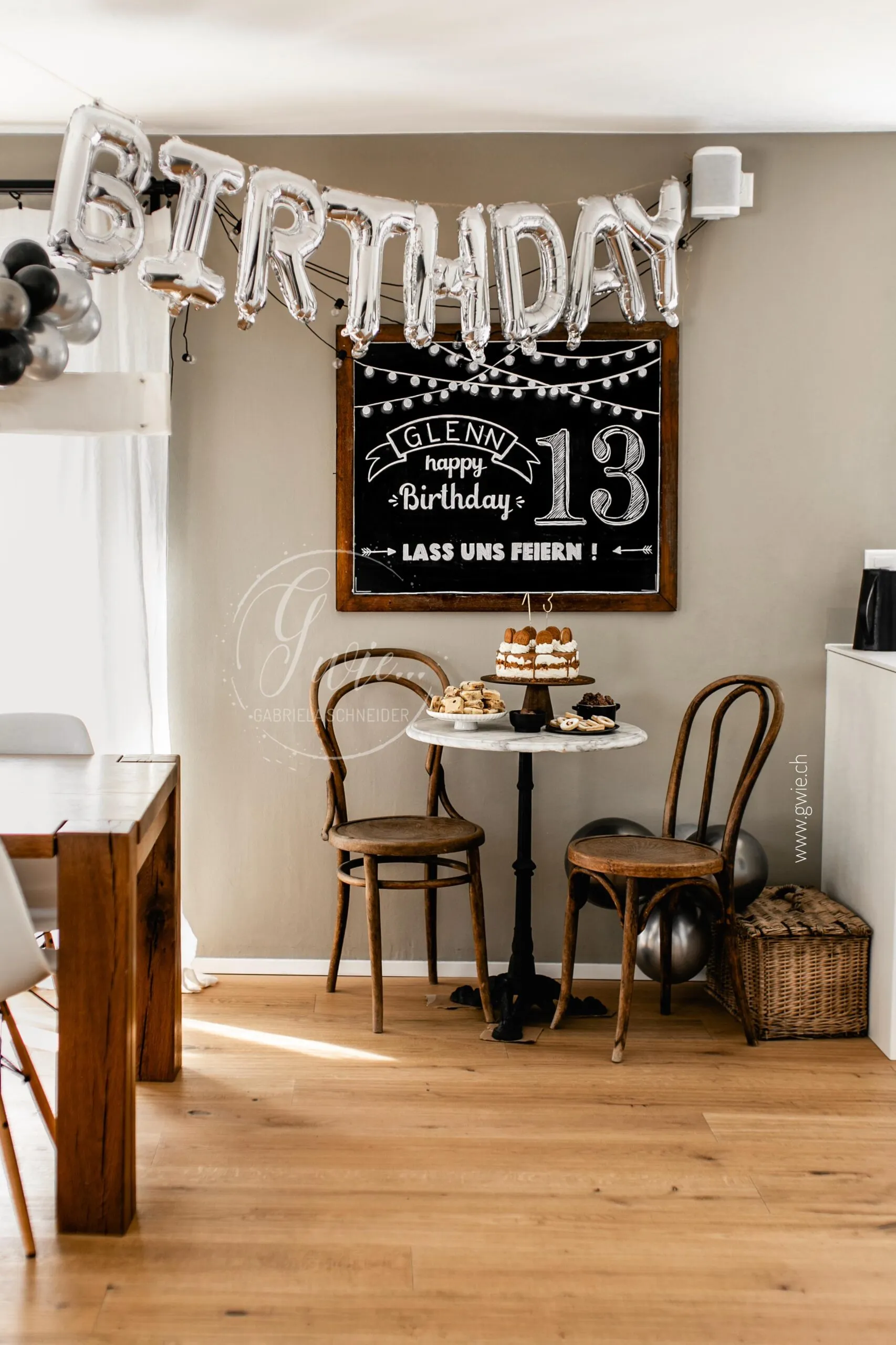 Glenns Geburtstag mit Lotustorte vor Chalkboard und Ballons