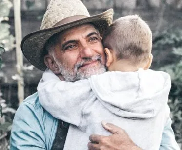 Glücklicher Vater mit Sohn auf dem Arm, symbolisiert Familienschutz