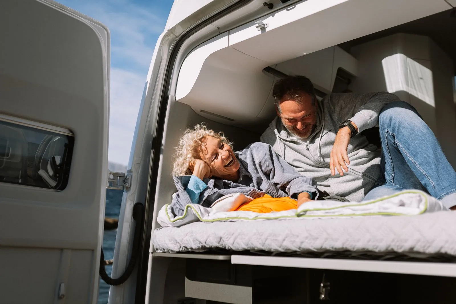 Glückliches Paar entspannt im Camper bei Sonnenschein