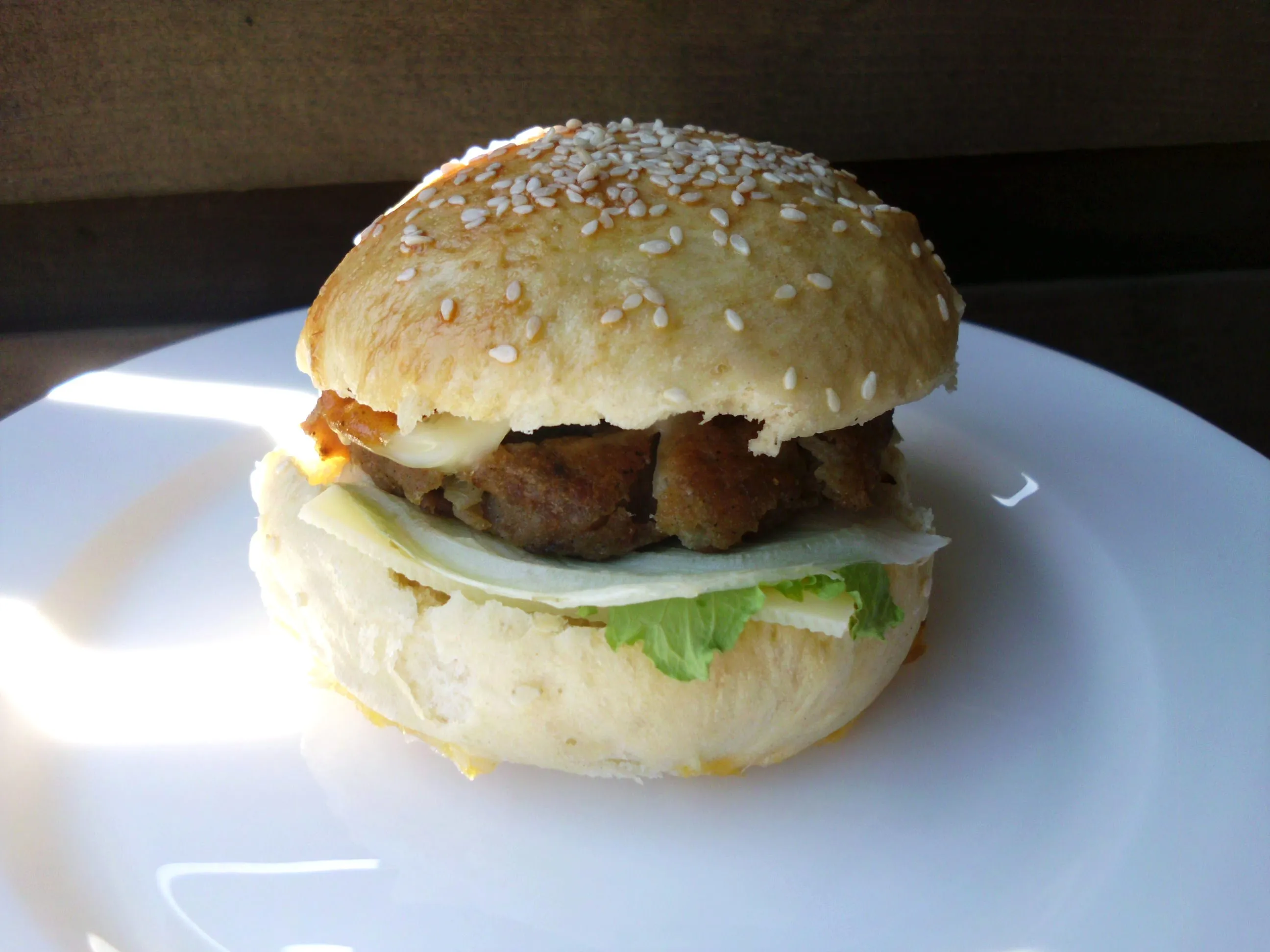 Goldbraune Hamburger Brötchen auf einem Holzbrettchen, bereit zum Füllen