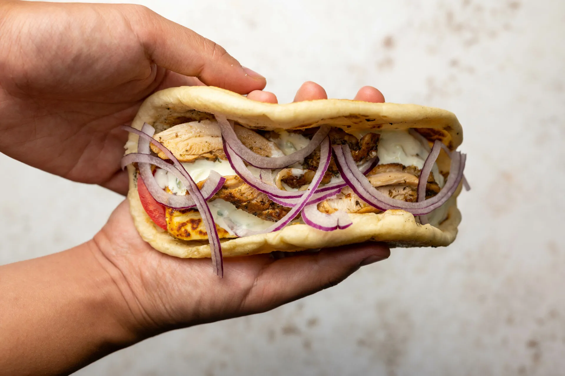 Griechisches Pita Brot frisch aus der Pfanne, daneben eine gefüllte Tasche