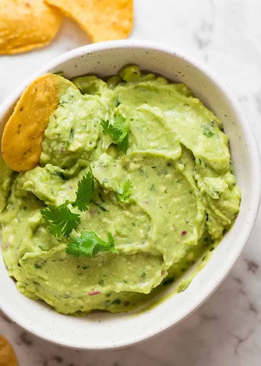 Guacamole in einer weißen Schüssel mit Maischips