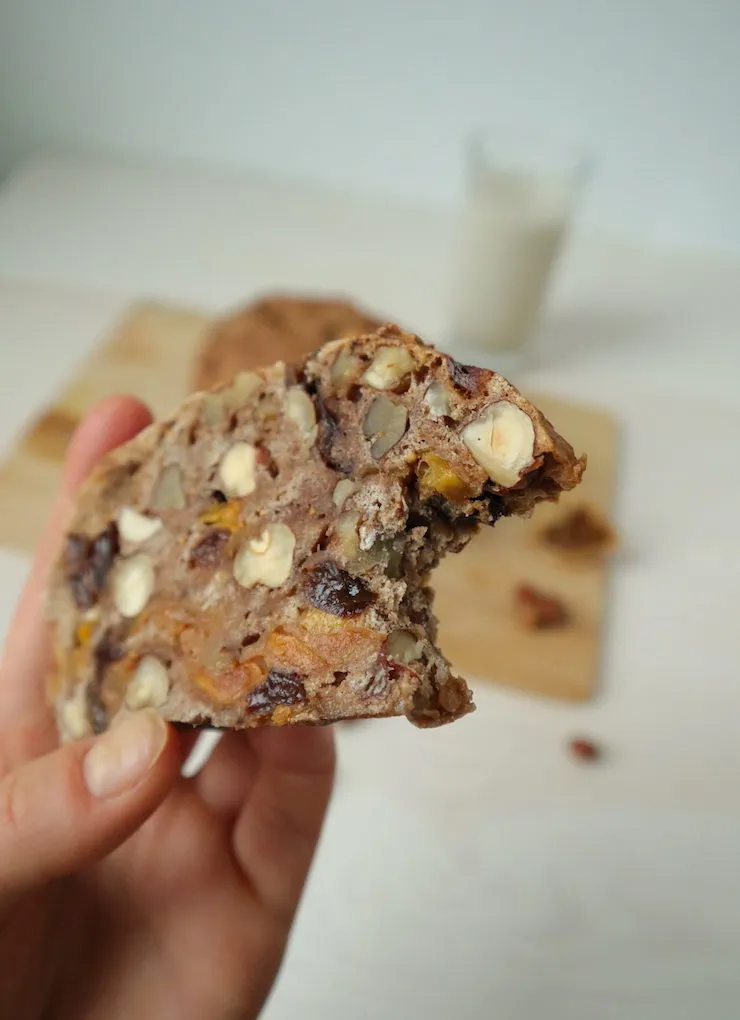 Hand hält ein Stück Vollkorn-Früchtebrot mit Nüssen