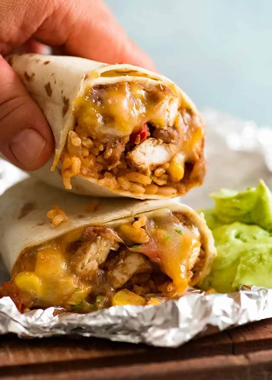 Hand nimmt Hähnchen Burrito auf