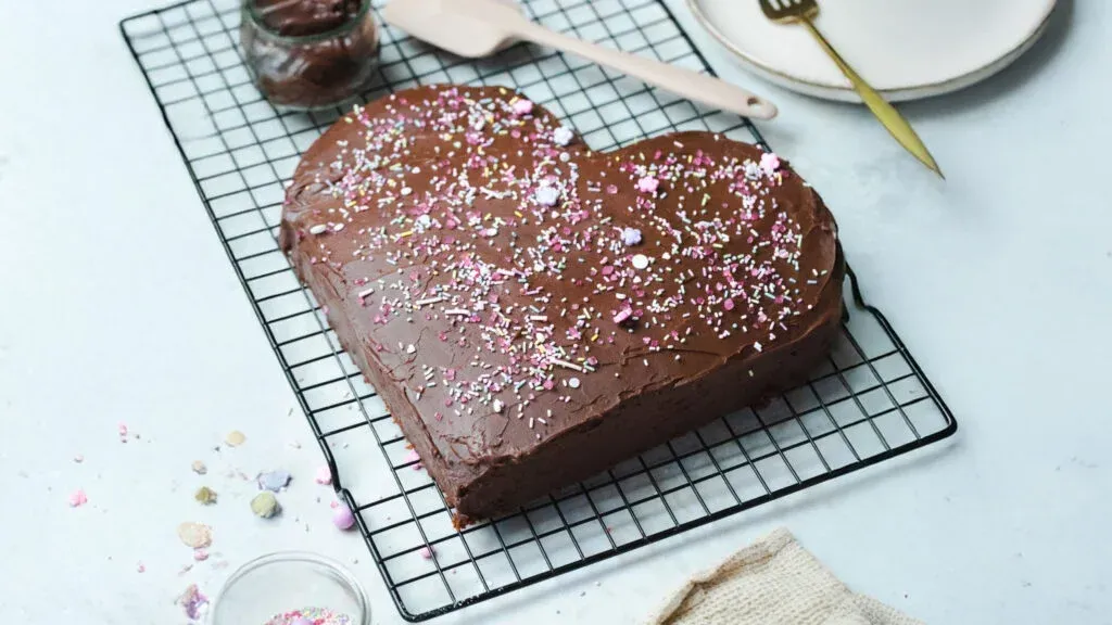 Herzkuchen aus Schokoladenteig mit Puderzucker bestäubt auf Kuchengitter