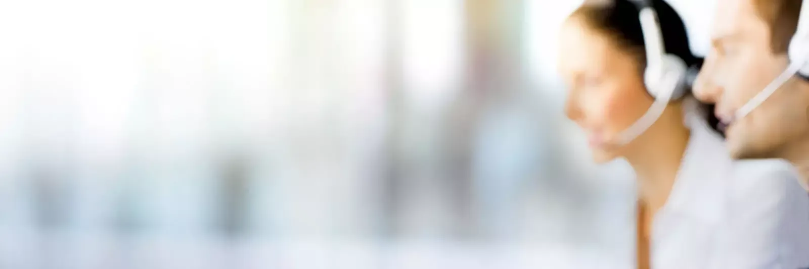 Im rechten Bildbereich zwei Köpfe von Call-Center-Mitarbeitern mit Headset