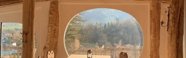 Innenansicht eines gemütlichen Erdhauses mit Herd und Küchentisch