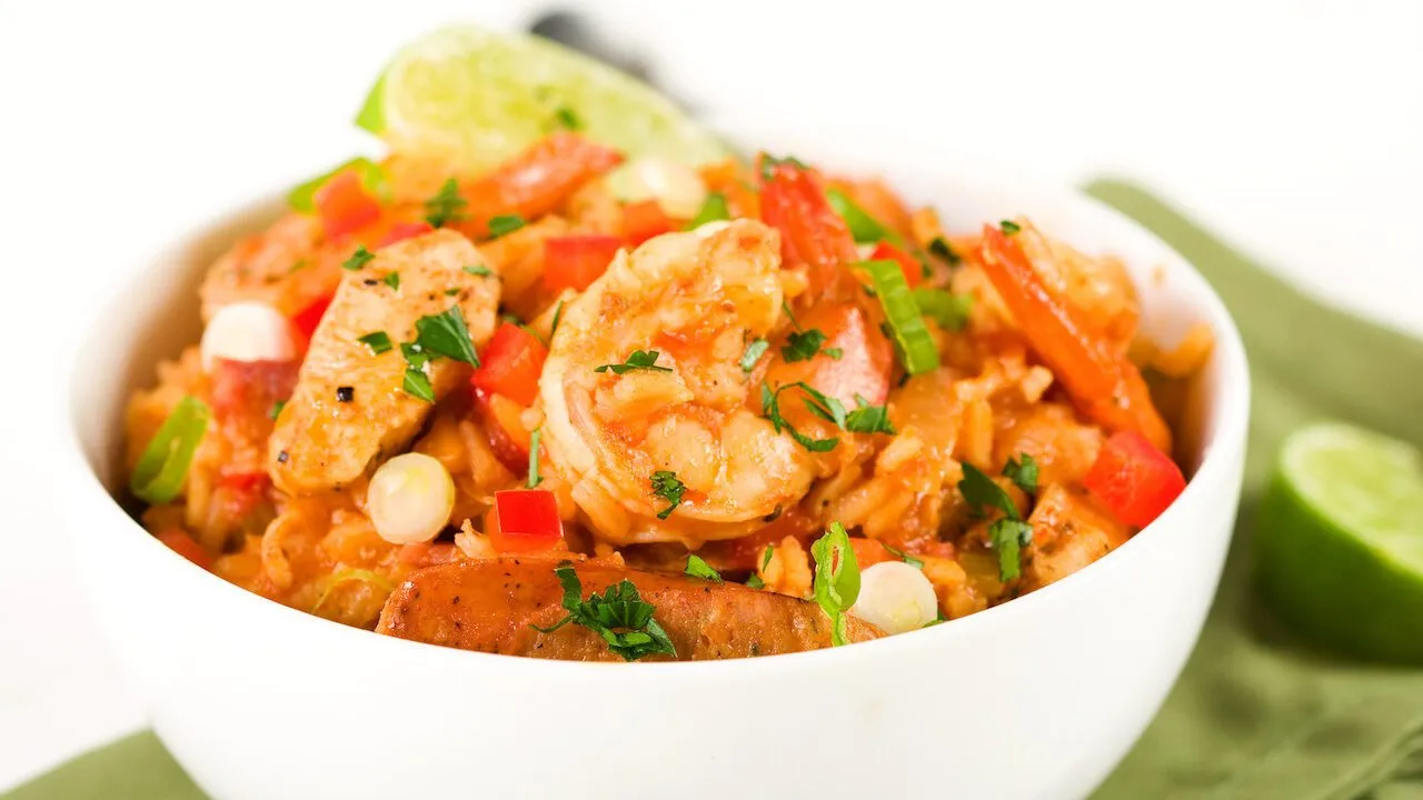 Jambalaya mit Garnelen, Schinken und Reis in einer Pfanne.