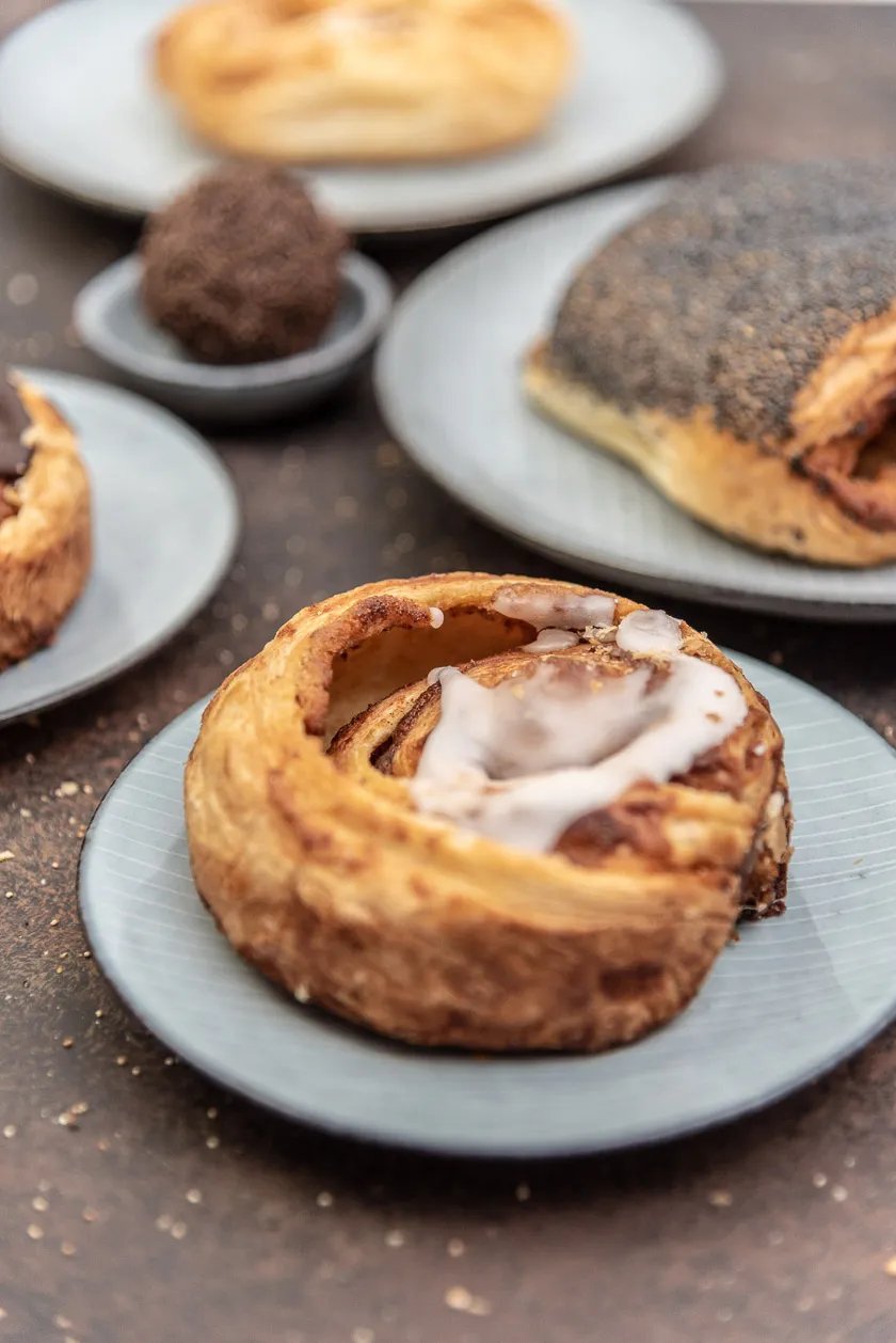 Kanelsnegle mit weißem Zuckerguss – Eine Zimtschnecke mit traditionellem Topping