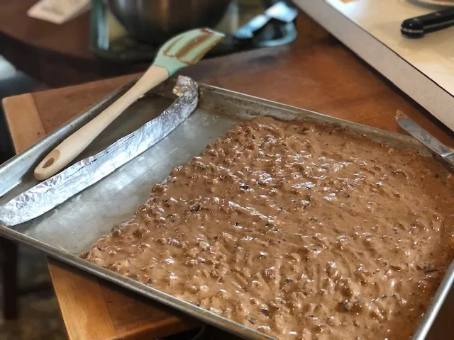 Keksteig wird auf einem Backblech ausgebreitet, um eine Dicke von etwa 1,2 cm zu erreichen.