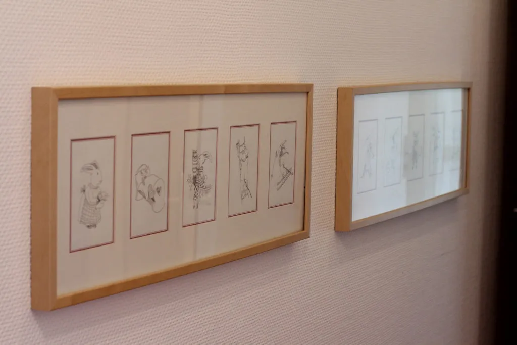 Kind sitzt an einem Tisch und wird von einer Erwachsenen beim Lernen begleitet