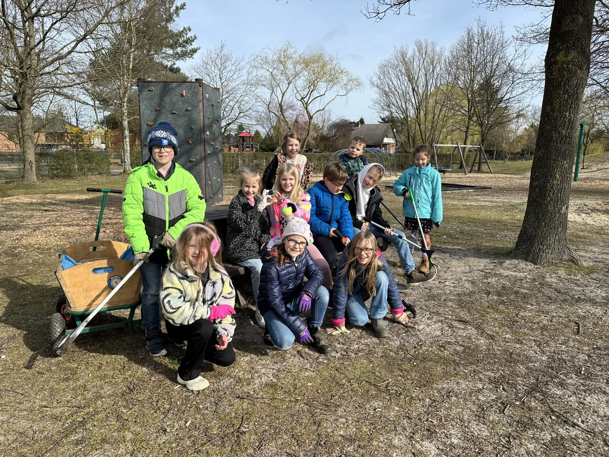 Kinder sammeln mit Müllzangen weggeworfenen Müll im Dorf