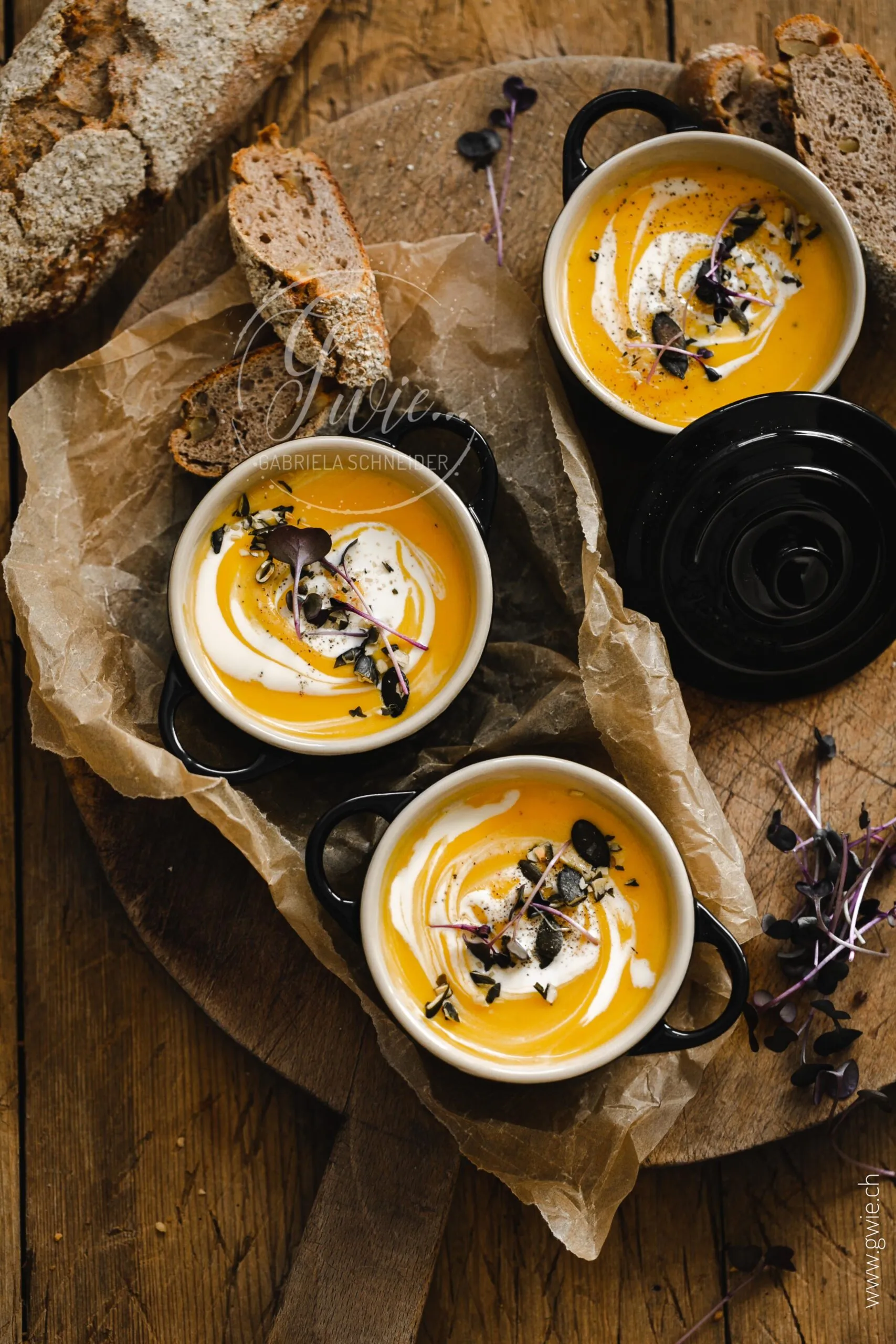 Kleine orangefarbene Kürbissuppe in einem Mini-Le Creuset Topf