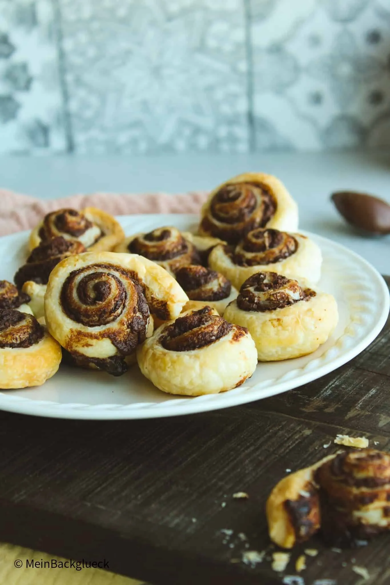 Knusprige Nutella Blätterteig Schnecken mit Puderzucker bestreut