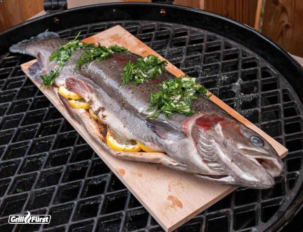 Lachsforelle wird auf einem Räucherbrett schonend gegrillt
