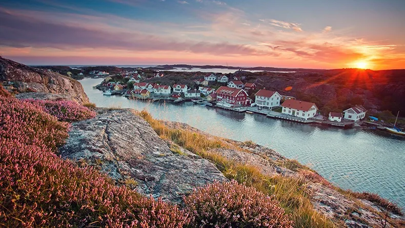 Malerische Landschaft in Schweden mit roten Holzhäusern am Wasser