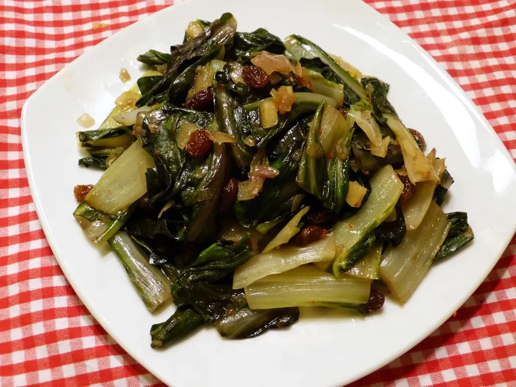 Mangoldgemüse mit Rosinen, Zimt und Cayennepfeffer in einer Pfanne