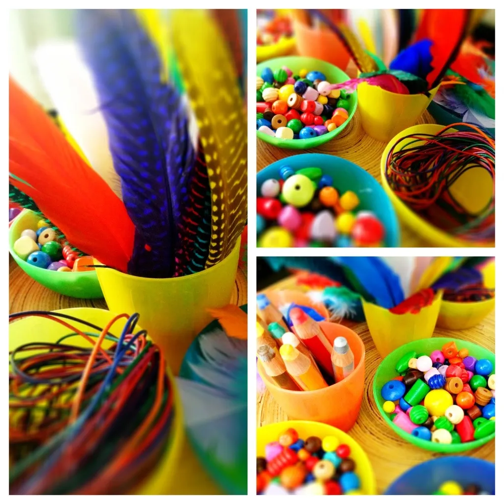 Materialien für Indianerschmuck: Federn, Wachsmalkreide, Lederbänder und Holzperlen