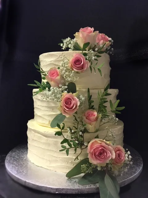 Mehrstöckige Hochzeitstorte in Weiß mit dezenten Verzierungen